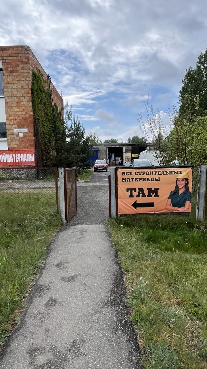 Оранжевый рекламный баннер магазина строительных материалов у входа на территорию